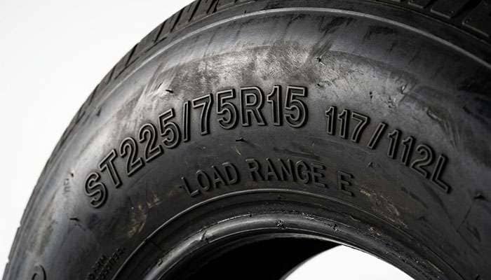 Close-up of an ST trailer tire sidewall showing the size marking with load index and L speed rating