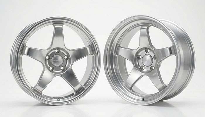 Staggered set of polished five-spoke wheels, narrower in front and wider in the rear, on a white studio backdrop