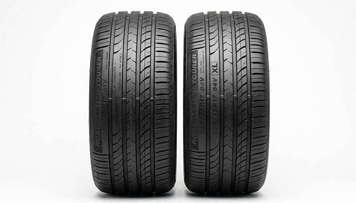 Side-by-side comparison of a standard load tire and an XL extra load tire of the same size with sidewall markings visible