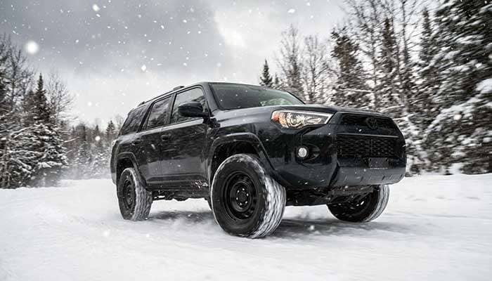 Vehicle equipped with steel wheels driving on a snow-covered road in winter conditions