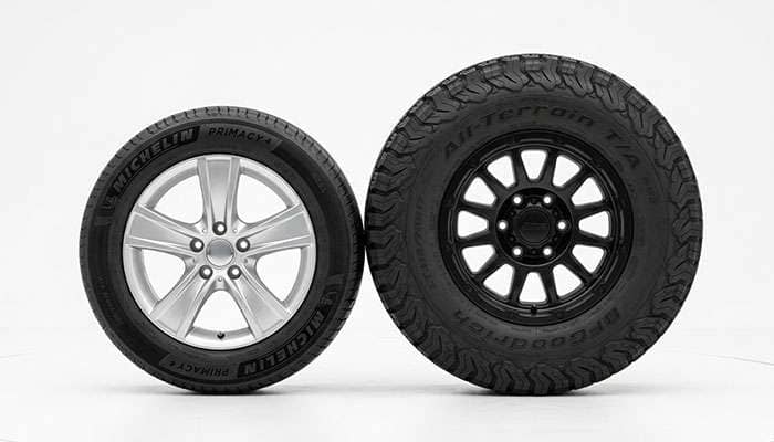 A stock car tire beside a taller larger-diameter tire for comparison