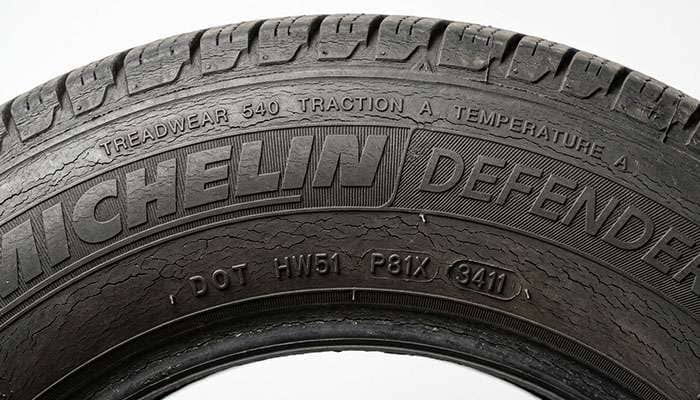 Close-up of fine weather checking and surface cracking on aged stored car tire sidewall