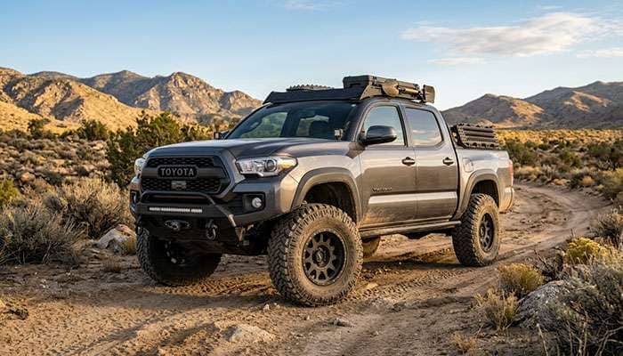 Front wheel well of a 3rd gen Toyota Tacoma showing the frame-mounted cab mount just behind a 35-inch tire turned to full lock