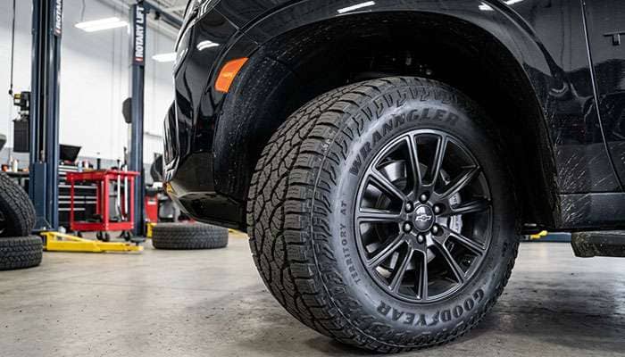 Front tire of a Chevy Tahoe turned to full steering lock showing the gap to the plastic fender liner