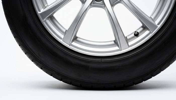 Tire bead seated evenly against an alloy wheel flange, showing a uniform centering line around the rim after inflation