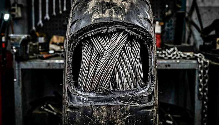 Close-up of high-tensile steel wire bundle inside a tire bead showing individual strands twisted together