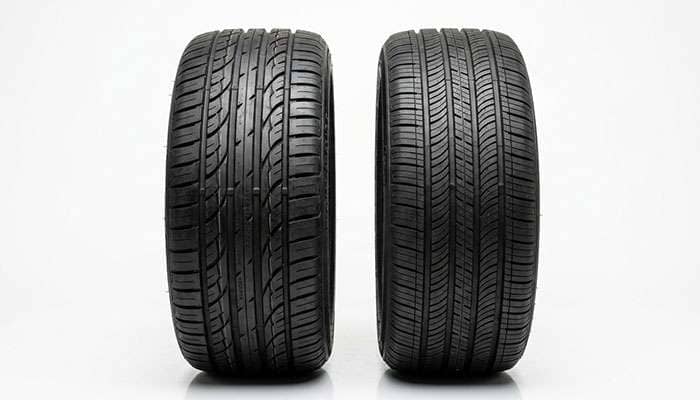 Side-by-side comparison display of budget and performance tires showing tread pattern differences