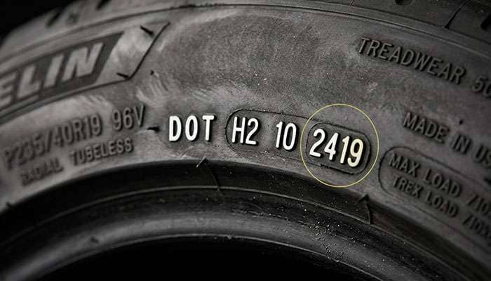 close-up of a tire sidewall showing the DOT code with the four digit manufacture date highlighted showing week and year of production