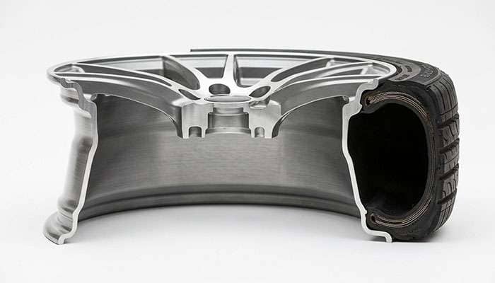Cutaway view of an aluminum wheel barrel showing the drop center well near the outboard flange where the tire bead drops during mounting