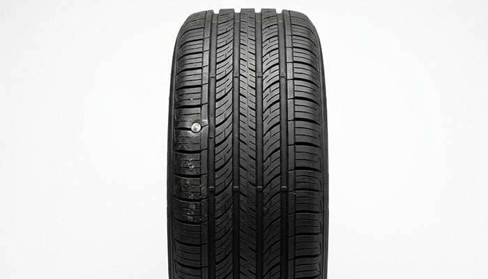 Nail embedded in the outer tread rib of a tire, outboard of the first major groove and outside the repairable crown area
