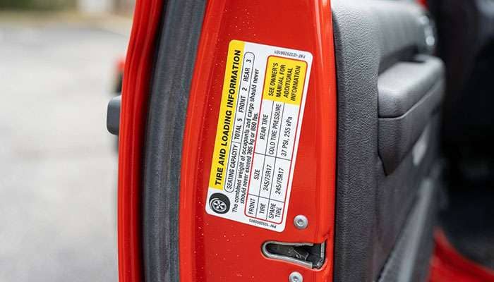 Tire and loading information placard on a Jeep door jamb listing 245/75R17 tires and cold inflation pressure