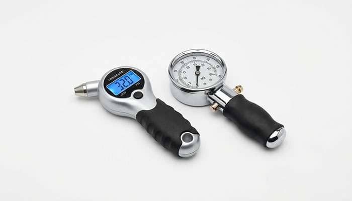 Digital and analog tire pressure gages showing PSI readings