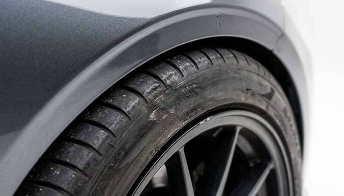 Tire sidewall with abrasion marks sitting tight under a lowered car's fender lip