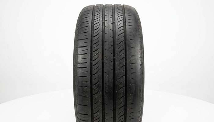 Tread face of a tire showing heavy wear on both outer shoulders with the center tread still intact, the classic underinflation wear signature