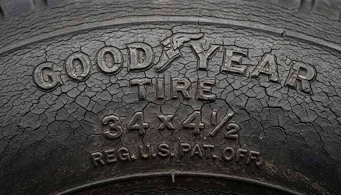 detailed view of tire sidewall showing dry rot cracking and surface checking on an aged vintage tire