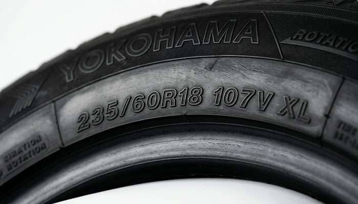 Close-up of a 235/60R18 tire sidewall showing the size, load index, and XL markings
