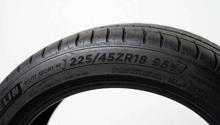 Close-up of tire sidewall size markings showing width aspect ratio and diameter