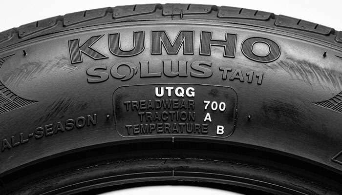Close-up of the UTQG treadwear traction and temperature stamp on a Kumho Solus TA11 sidewall