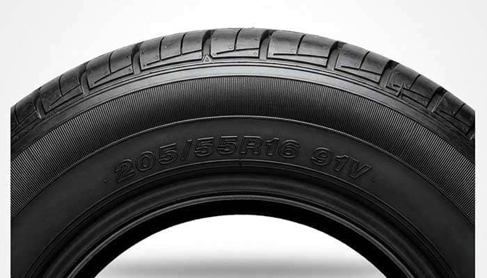 Close-up of a tire showing speed rating 91V with text comparing tire speed ratings H vs V