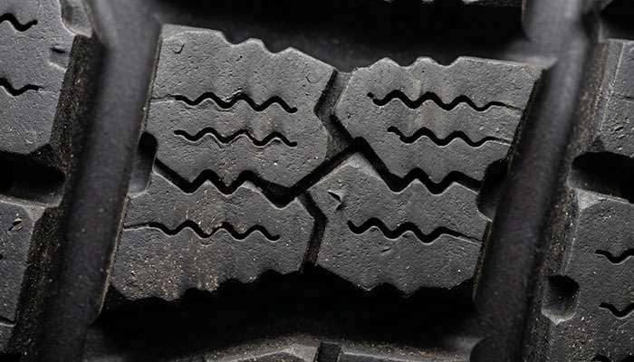 Close-up of an off-road tire tread block showing 3D sipes and full-depth siping cuts that improve wet and snow traction