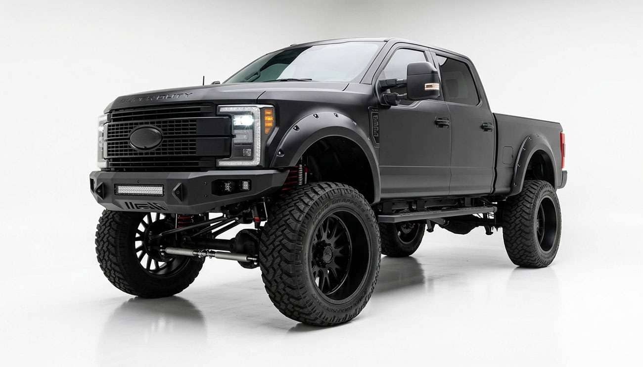 Lifted pickup truck fitted with 24x14 wheels and wide off-road tires viewed from the front three quarter angle