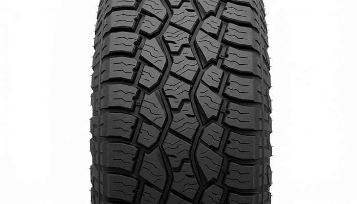 Toyo Open Country A/T III aggressive all-terrain tread pattern with stone ejector blocks on a clean studio backdrop