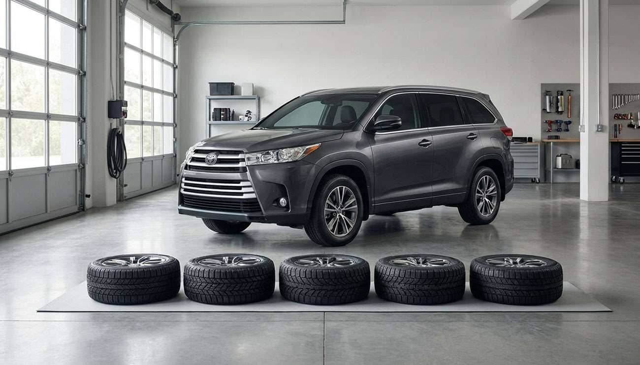 Toyota Highlander parked in a garage with aftermarket tires laid out in front for installation