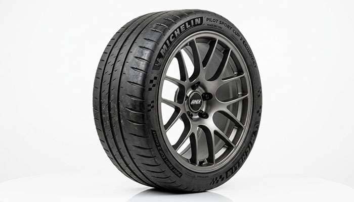 Track day tire mounted on a lightweight track-style alloy wheel showing aggressive tread pattern and stiff sidewall construction