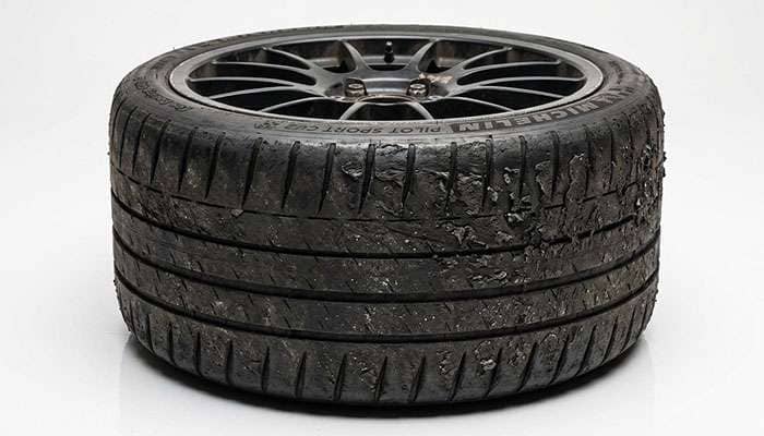 Performance tire shoulder with heavy wear and rollover marks from running too little pressure on track