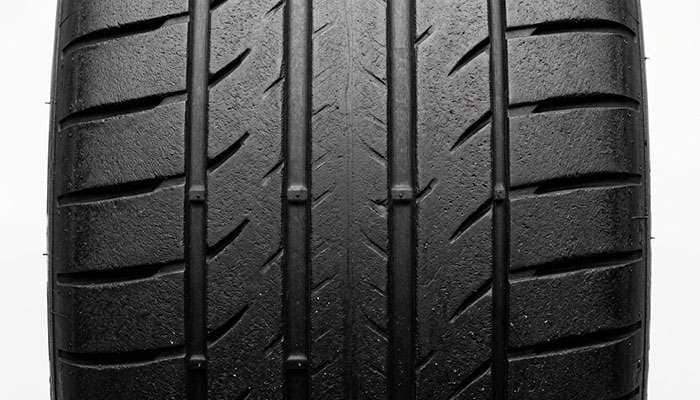 Close-up of a track day tire tread showing minimal void area and aggressive shoulder blocks engineered for maximum dry grip