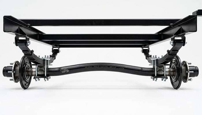 Leaf spring trailer axle beam with a slight upward arch mounted under an empty utility trailer frame