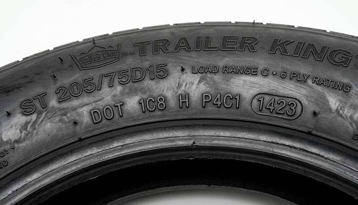 Close-up of the DOT date code molded into a trailer tire sidewall showing the four-digit week and year of manufacture