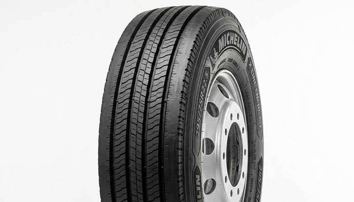 Close-up of a commercial trailer tire with shallow ribbed tread and reinforced sidewall