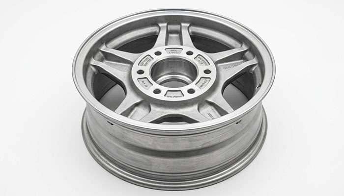 Back side of a six-lug truck alloy wheel showing the stamped maximum load rating and offset markings on the mounting pad