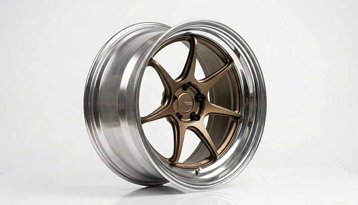 Close-up of a tuner wheel showing deep concave spoke design and polished lip on a clean white surface