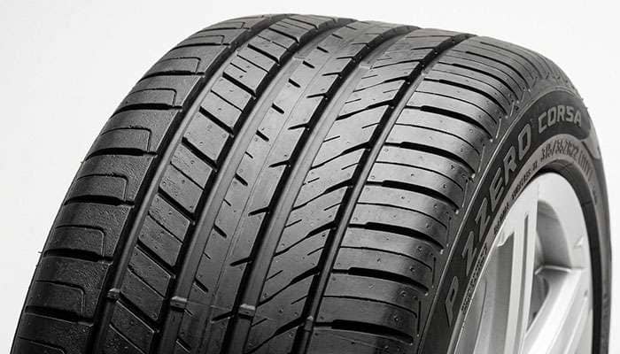 Close-up of an ultra-high-performance SUV tire tread pattern showing asymmetric design with reinforced shoulder blocks for heavy vehicle cornering loads