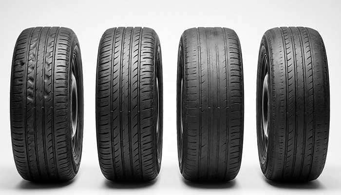 Passenger car tires showing various uneven wear patterns, highlighting different types of tread damage and wear issues