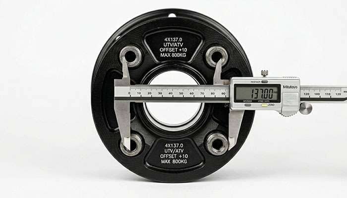 Measuring the bolt pattern on a UTV wheel hub showing lug spacing