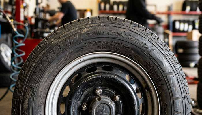 Close-up of a commercial van tire sidewall showing the size, dual load index and load range markings