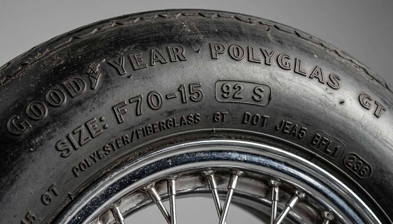 Close-up of a vintage classic car tire sidewall showing the molded speed rating letter code and DOT markings typical of 1960s and 1970s passenger car tires