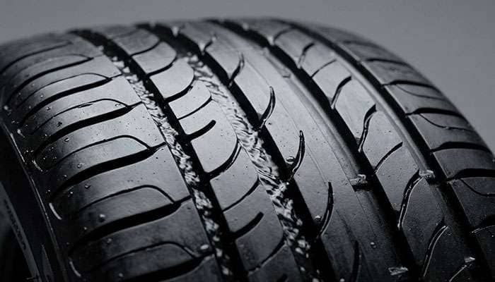 Macro close-up of tire tread groove showing water evacuation channel
