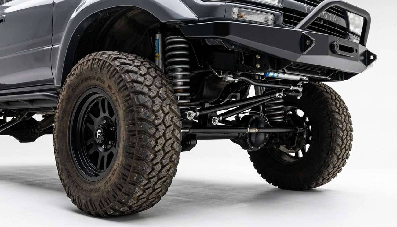 Lifted solid-axle truck front suspension and off-road tire shown in detail