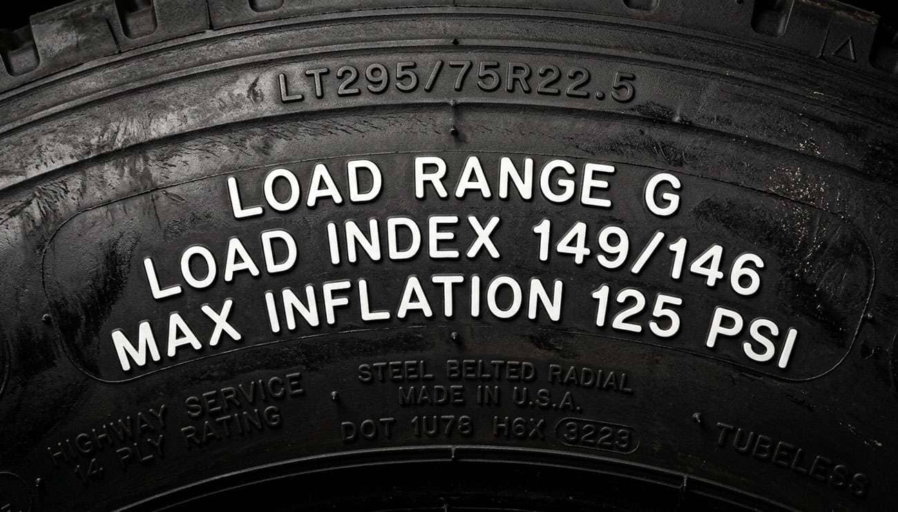 close-up of a truck tire sidewall showing load index and maximum pressure ratings stamped into the rubber