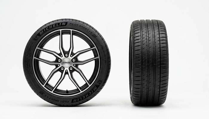 A complete wheel and tire assembly beside a single tire on a clean white studio backdrop