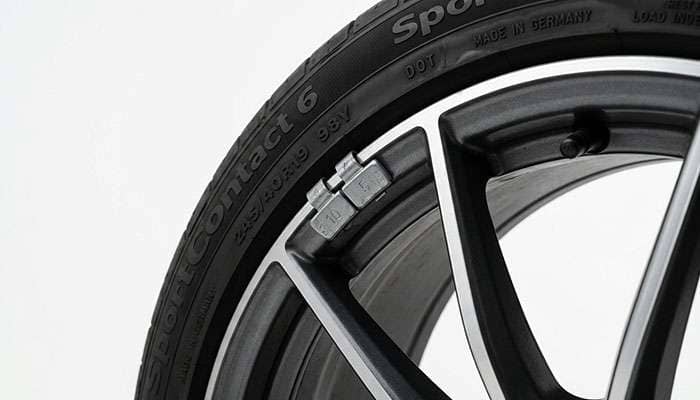 Small clip-on wheel weights installed on the rim lip during tire balancing