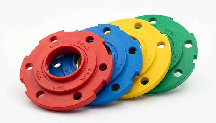Set of four colorful plastic wheel bolt pattern template tools with multiple hole sizes for measuring bolt patterns
