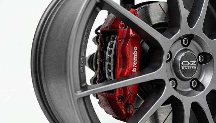 View through wheel spokes showing the brake caliper and rotor with the clearance gap between caliper and wheel barrel