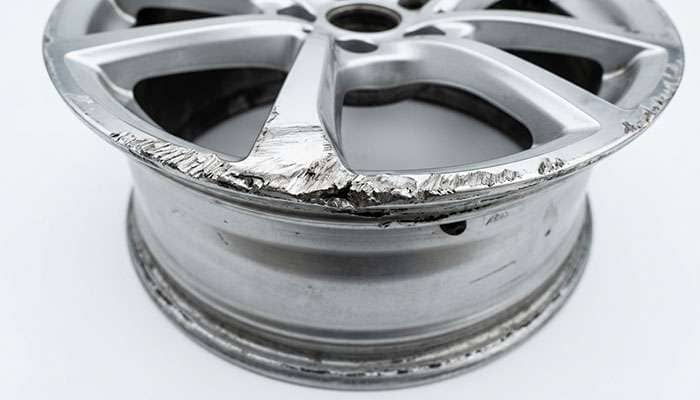 Close-up of curb rash gouges along the outer lip of an alloy wheel