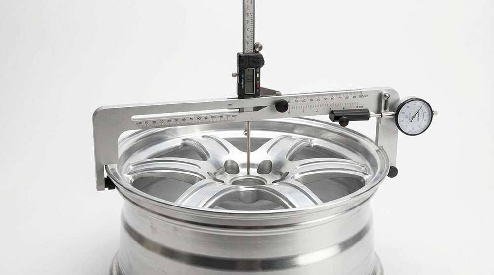 WheelWise Wheel Fitment Simulator tool measuring wheel offset and backspacing on a tire rim with logo and text overlay