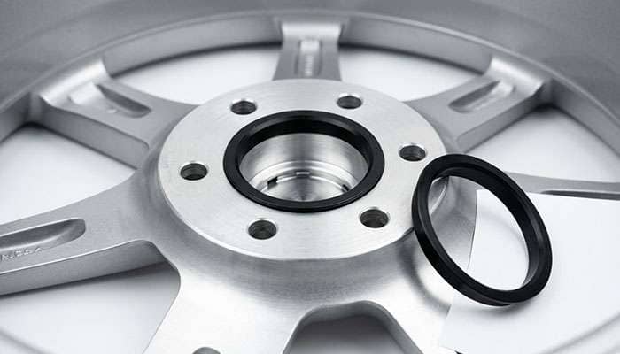 Aftermarket wheel center bore shown with a plastic hub centric ring seated inside it to reduce the bore diameter